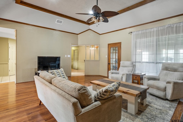 living room featuring ornamental molding, a textured ceiling, ceiling fan, hardwood / wood-style floors, and lofted ceiling