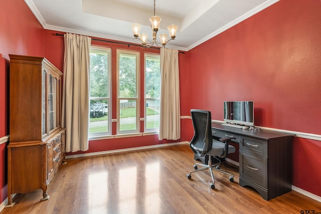 office area featuring a raised ceiling, light hardwood / wood-style flooring, a chandelier, and ornamental molding