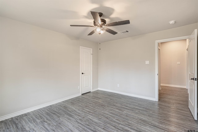 empty room with dark hardwood / wood-style flooring and ceiling fan