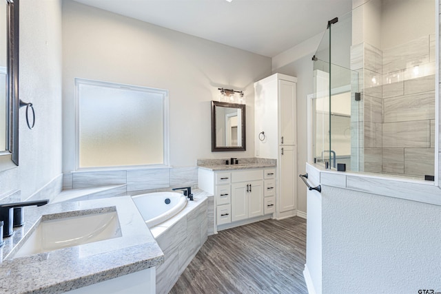 bathroom featuring independent shower and bath, hardwood / wood-style floors, and vanity