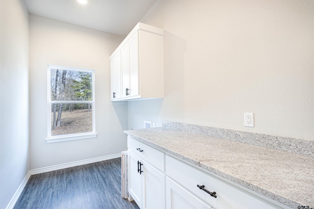 laundry room featuring washer hookup, dark wood-type flooring, and cabinets