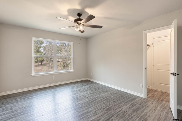 empty room with ceiling fan and dark hardwood / wood-style floors