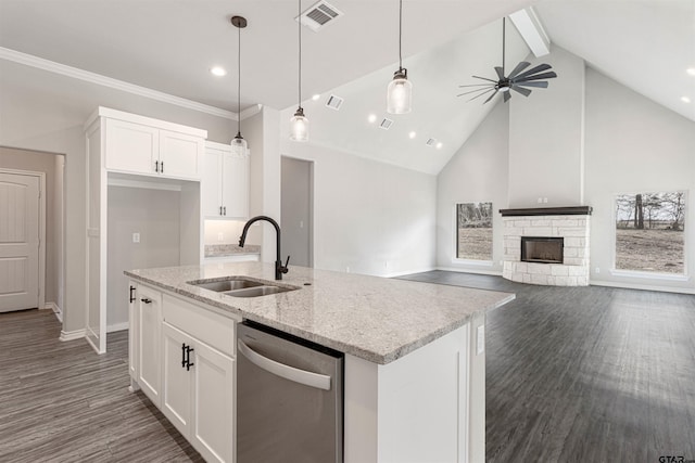 kitchen featuring light stone counters, white cabinetry, dishwasher, and sink