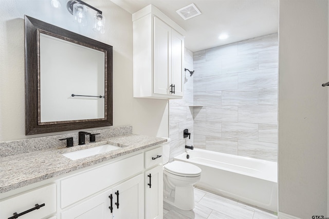 full bathroom with toilet, tiled shower / bath combo, and vanity