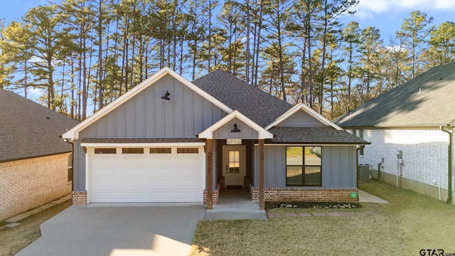 view of front facade featuring a garage, cooling unit, and a front lawn