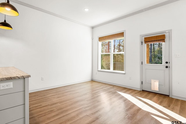 unfurnished living room with ornamental molding and light wood-type flooring