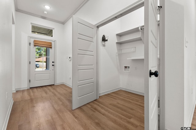 washroom with crown molding, washer hookup, and light hardwood / wood-style flooring