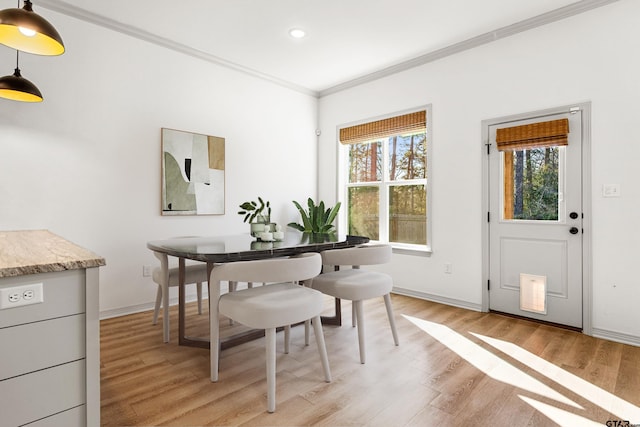 dining area featuring ornamental molding and light hardwood / wood-style floors