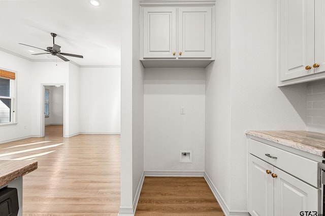 clothes washing area with ceiling fan and light hardwood / wood-style floors