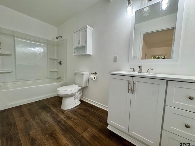 bathroom with baseboards, toilet, wood finished floors,  shower combination, and vanity