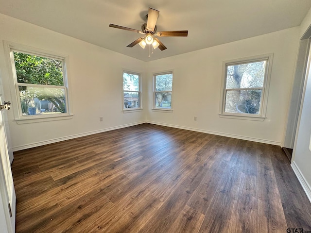 unfurnished room with dark wood-style floors, ceiling fan, and baseboards