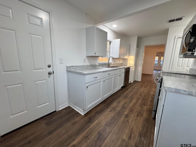 kitchen with stainless steel appliances, a sink, baseboards, light countertops, and dark wood-style floors