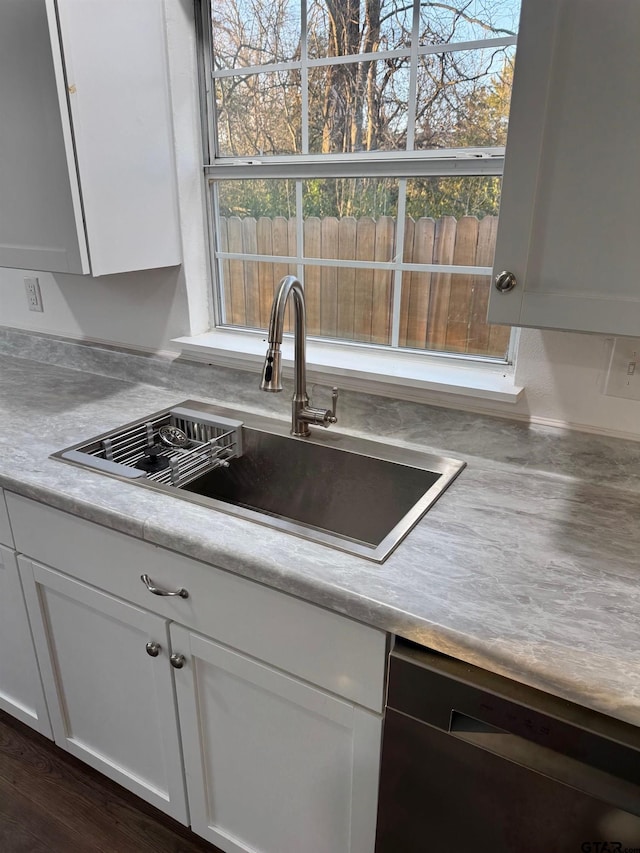 kitchen featuring a sink, white cabinetry, light countertops, and dishwasher