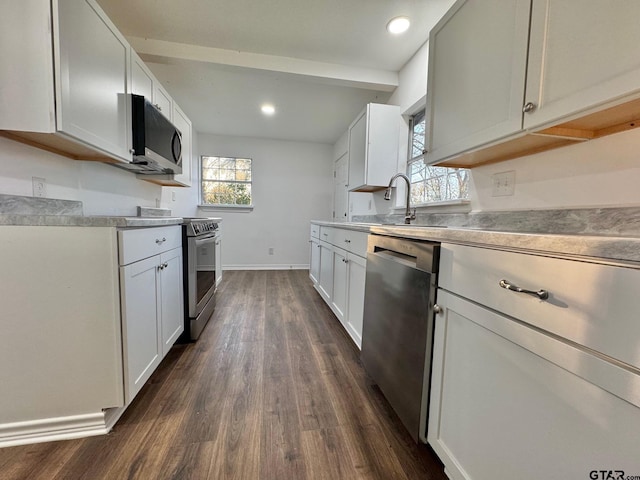 kitchen with baseboards, dark wood finished floors, stainless steel appliances, light countertops, and a sink