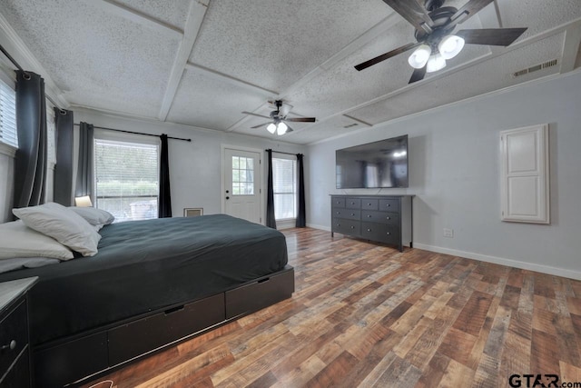 bedroom with hardwood / wood-style floors, ceiling fan, a textured ceiling, and crown molding