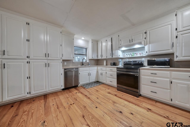 kitchen featuring light hardwood / wood-style flooring, white cabinetry, sink, and stainless steel appliances