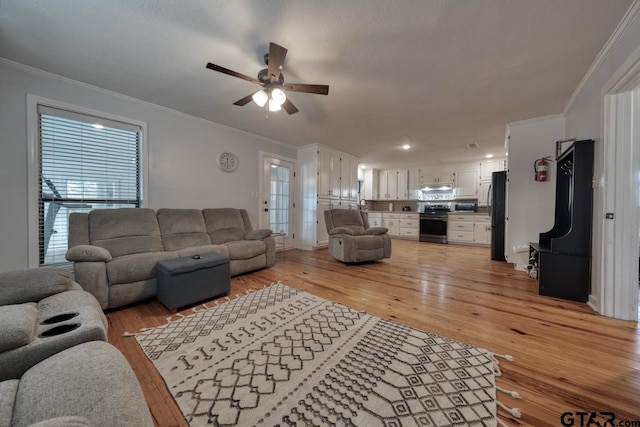 living room with ceiling fan, light hardwood / wood-style floors, and crown molding