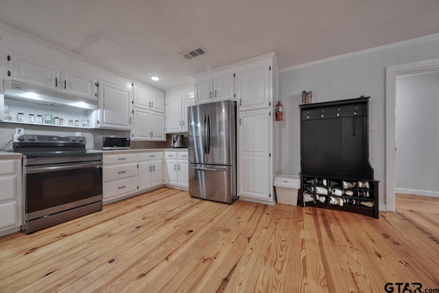 kitchen with light hardwood / wood-style floors, white cabinetry, appliances with stainless steel finishes, and ornamental molding