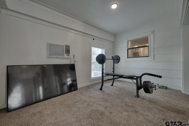 workout room featuring carpet and an AC wall unit