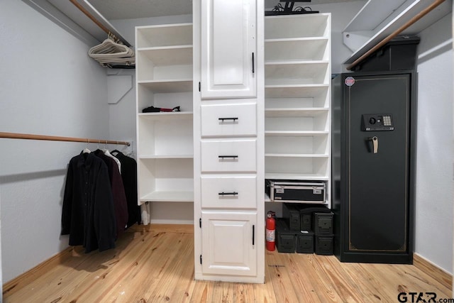 walk in closet with light wood-type flooring