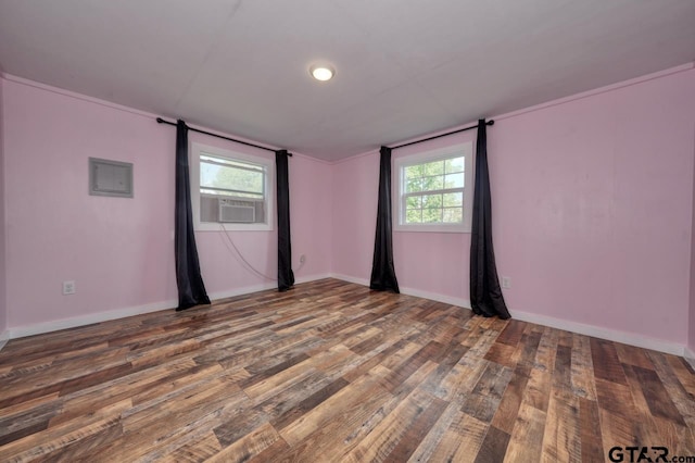 empty room with a wealth of natural light, dark hardwood / wood-style floors, and cooling unit