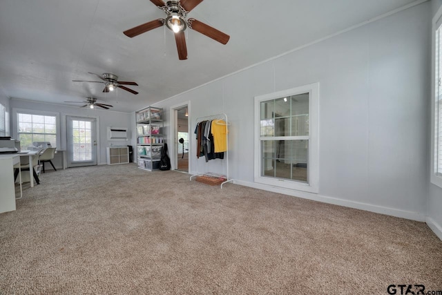 unfurnished living room featuring carpet flooring, ceiling fan, and crown molding