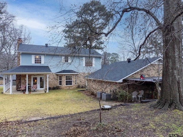 back of property with a lawn and a patio area