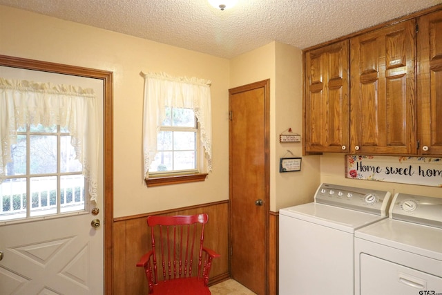 clothes washing area featuring cabinets, separate washer and dryer, plenty of natural light, and a textured ceiling