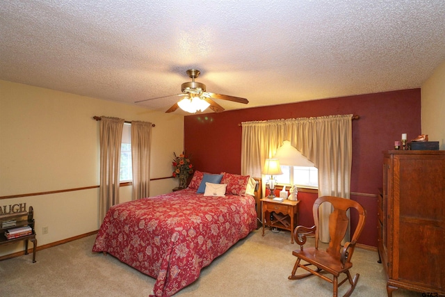 carpeted bedroom with multiple windows, a textured ceiling, and ceiling fan