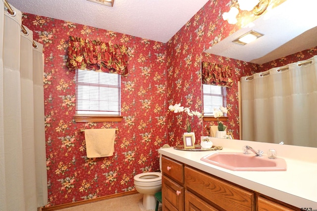 bathroom with vanity, toilet, and a textured ceiling