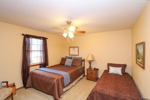 carpeted bedroom featuring ceiling fan and a textured ceiling