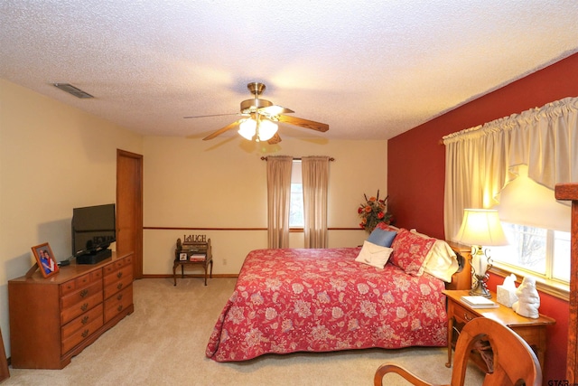 carpeted bedroom featuring a textured ceiling and ceiling fan