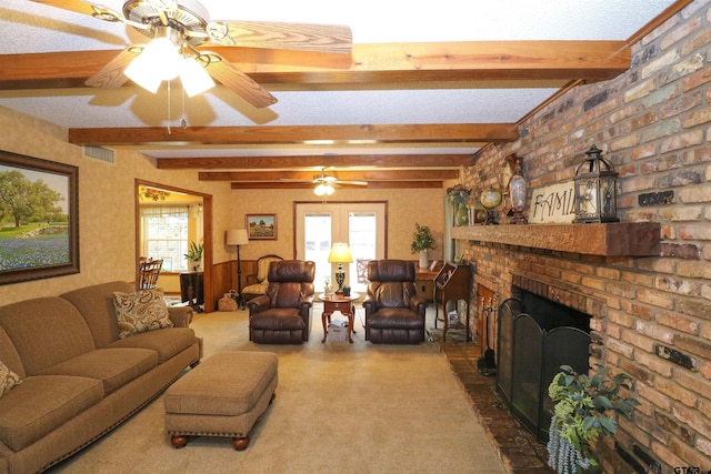 living room with ceiling fan, a brick fireplace, and beam ceiling