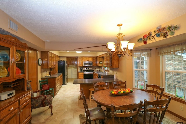 dining room with sink, a notable chandelier, and a textured ceiling