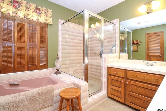 bathroom featuring vanity, separate shower and tub, and a textured ceiling