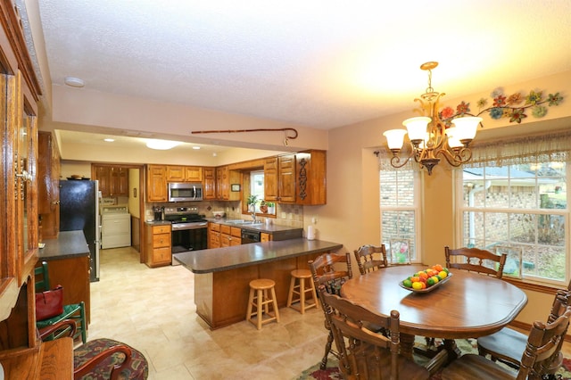 dining area with washer / clothes dryer, sink, a textured ceiling, and a notable chandelier