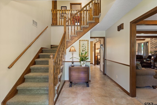 408 E Forest Dr, White Oak, TX 75693 - stairs featuring beam ceiling, baseboards, and tile patterned flooring