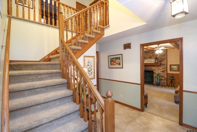 stairway featuring carpet floors and a brick fireplace