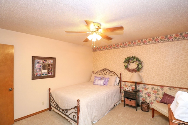 carpeted bedroom featuring ceiling fan and a textured ceiling