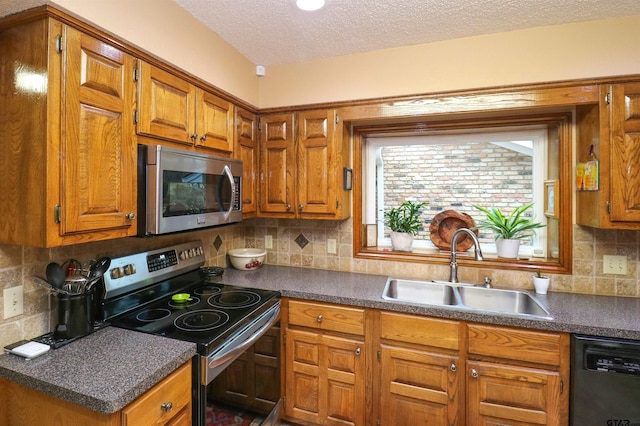 kitchen featuring sink, decorative backsplash, stainless steel appliances, and a textured ceiling