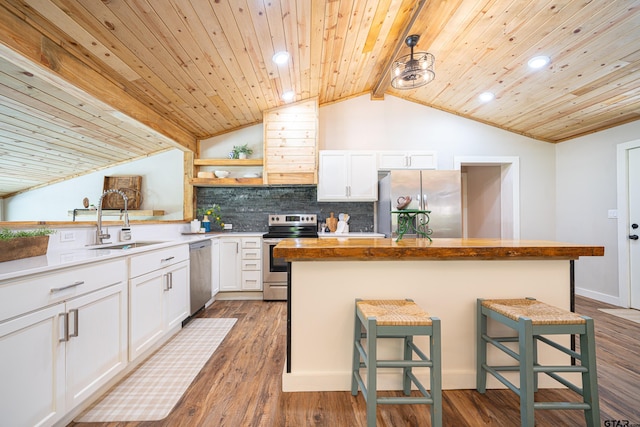 kitchen featuring sink, a breakfast bar, appliances with stainless steel finishes, white cabinets, and a kitchen island