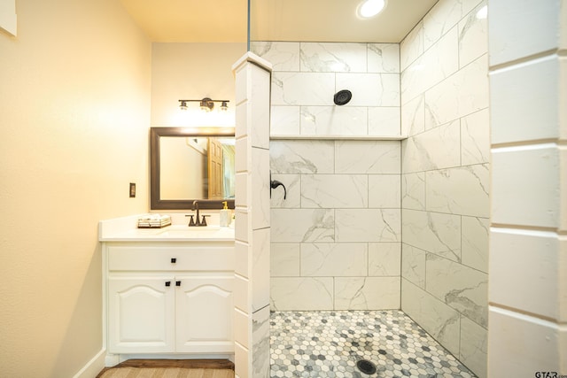 bathroom with vanity and tiled shower