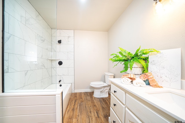 full bathroom with tiled shower / bath, wood-type flooring, toilet, and vanity