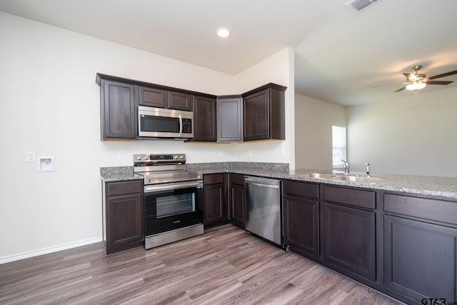1439 Monterey Dr, Longview, TX 75601 - kitchen featuring stainless steel appliances, light wood-type flooring, dark brown cabinetry, ceiling fan, and recessed lighting