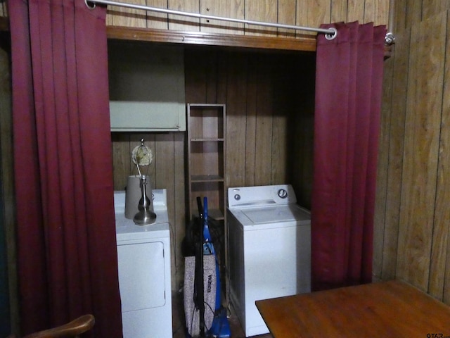 laundry room with washer and clothes dryer and wood walls