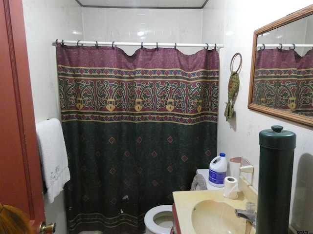 bathroom featuring toilet, curtained shower, and sink