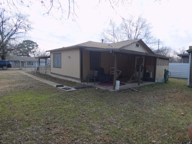 rear view of house featuring a patio and a lawn