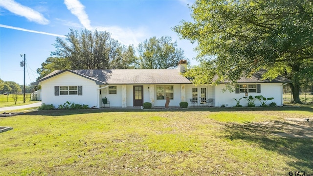 single story home featuring french doors and a front lawn