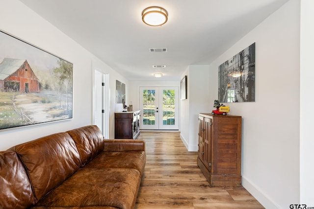 hall with light wood-type flooring and french doors