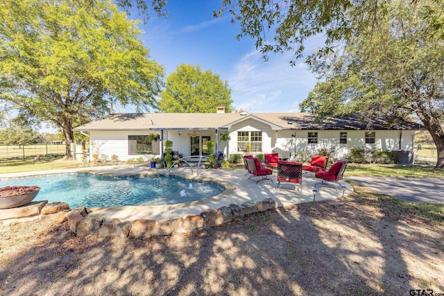 back of house with a fenced in pool, a patio area, and an outdoor hangout area